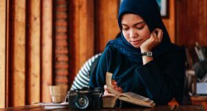 Image of woman in a hijab reading at a table