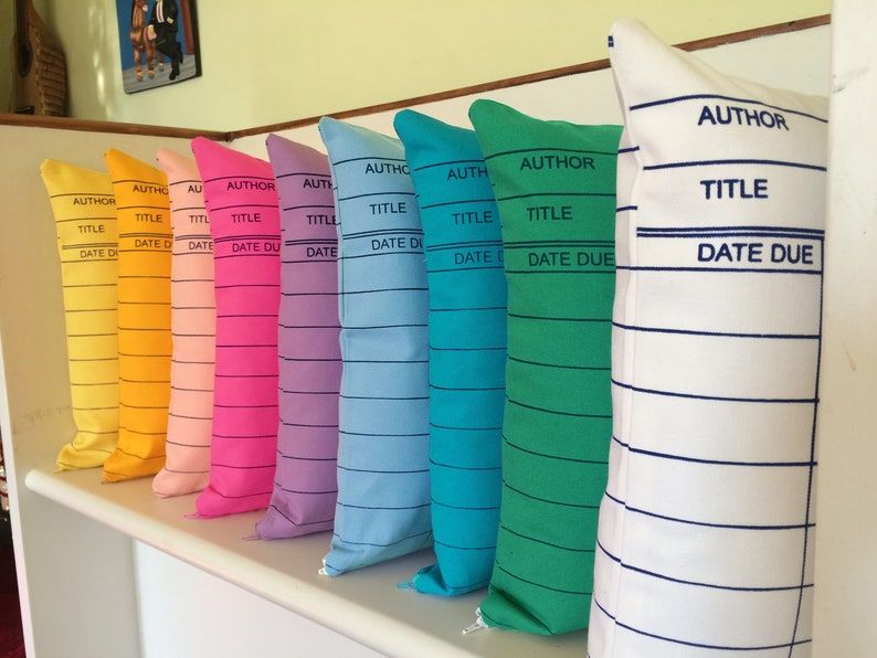 Image of a rainbow of pillows designed like library cards.