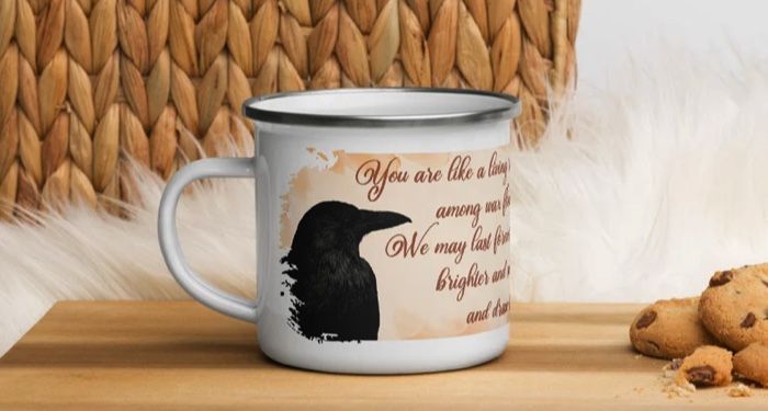 A mug with a raven and the quote "You are like a living rose among wax flowers. We may last forever, but you bloom brighter and smell sweeter, and draw blood with your thorns.”
