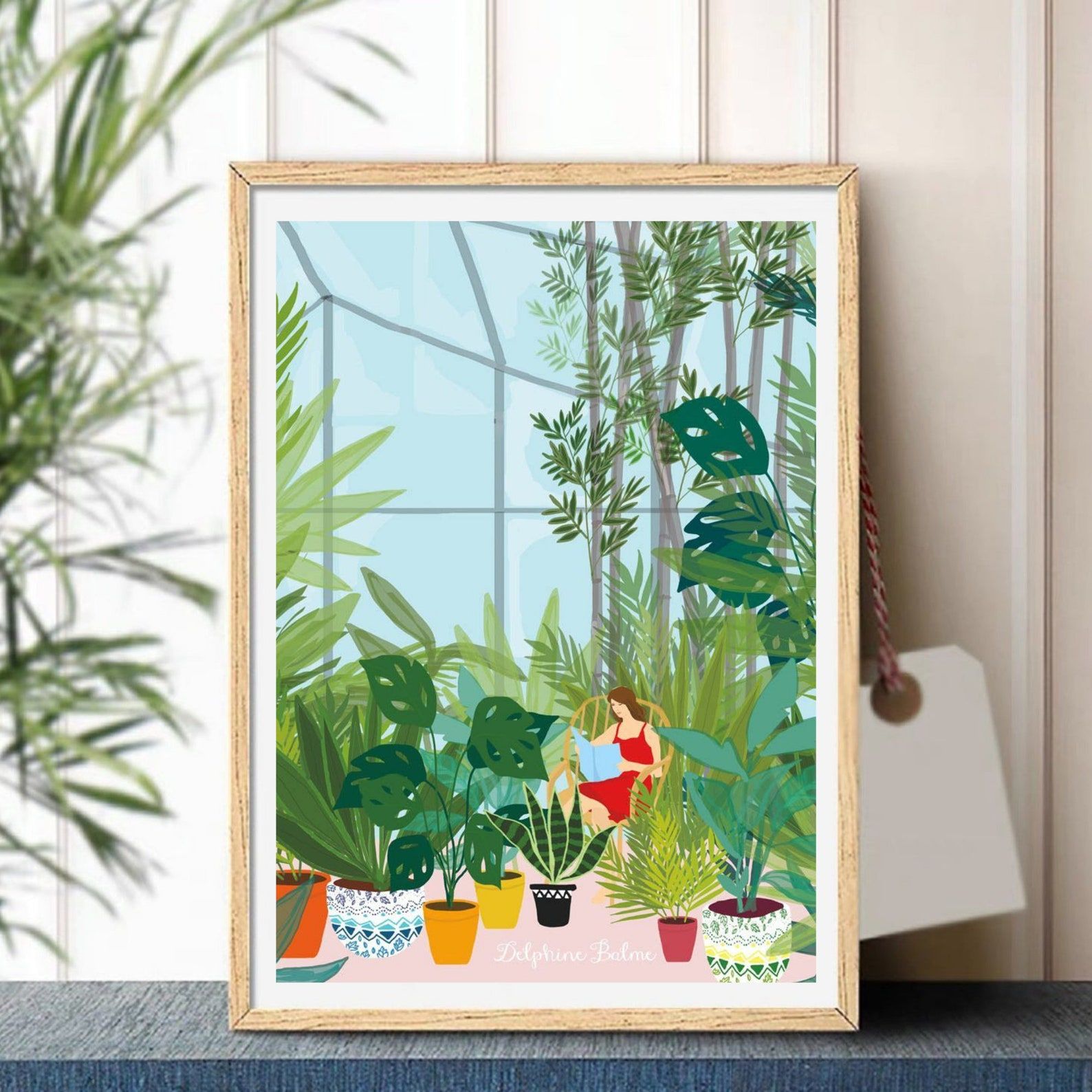 Image of a finished paint by numbers kit featuring a white woman reading in a solarium surrounded by plants. 