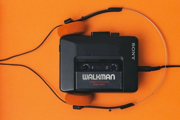 a Sony walkman and headphones against an orange background 