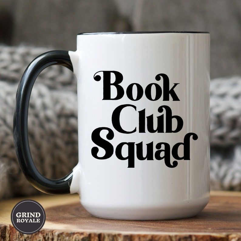 Image of a white mug with a black handle. It has black text reading "book club squad."