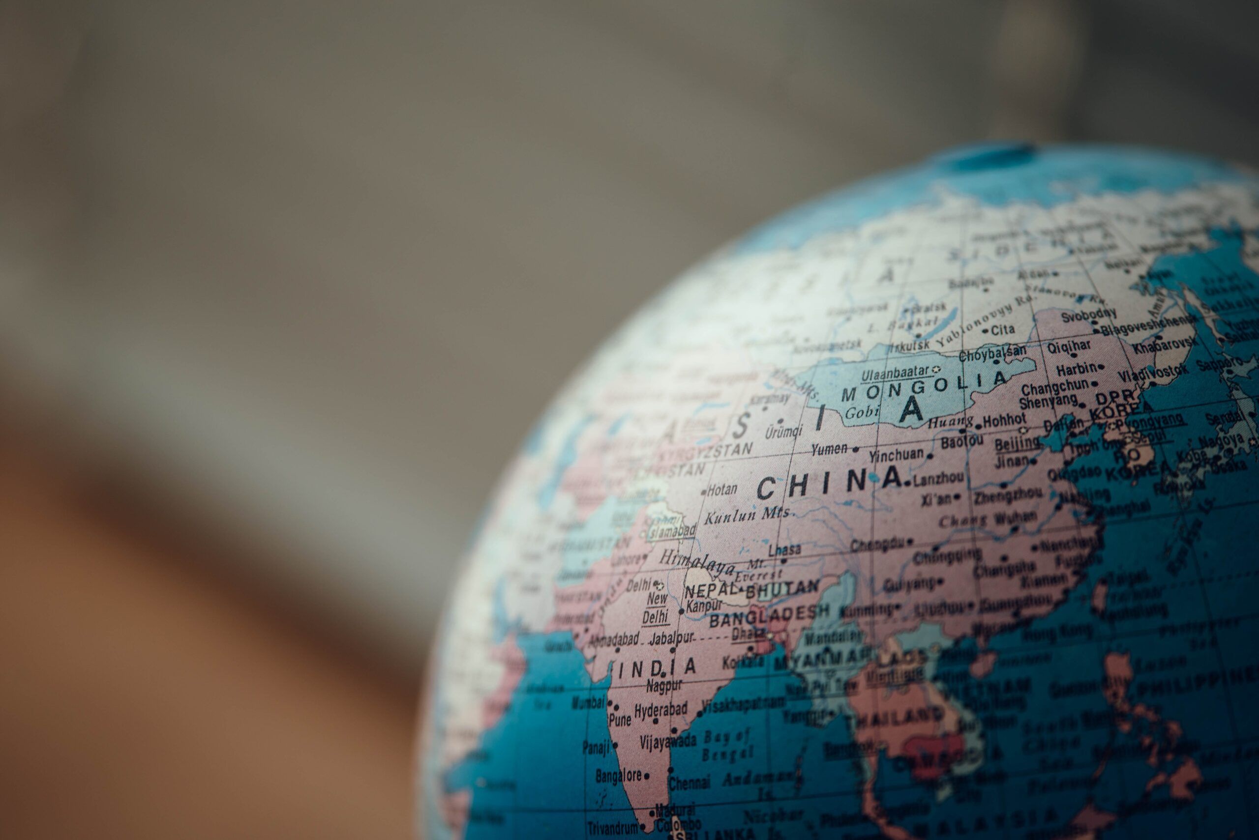 a close up photo of blue desk globe showing the continent of Asia