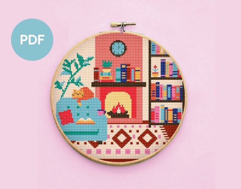 Image of a cross stitch pattern featuring a cozy chair, fireplace, cat, plants, and many books. 