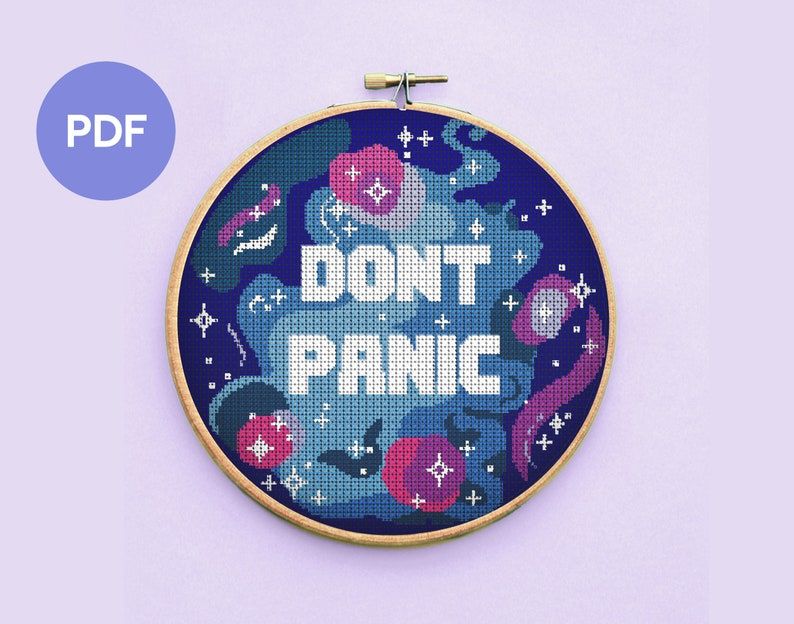 Brightly colored cross stitch with the words "don't panic."