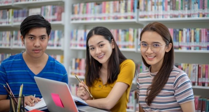 image of three young people in a library