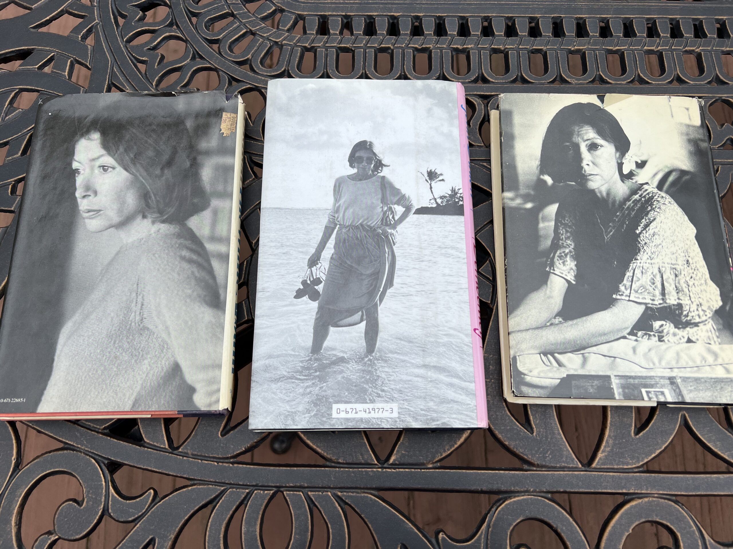 Author photos from three older editions of Joan Didion's books sitting on an iron table. [Photo by Alex Luppens-Dale]