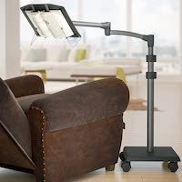 a promotional photo for a metal and plastic hands-free book stand that hover over your couch, chair, or bed