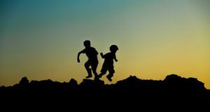 silhouette of two children playing at dusk