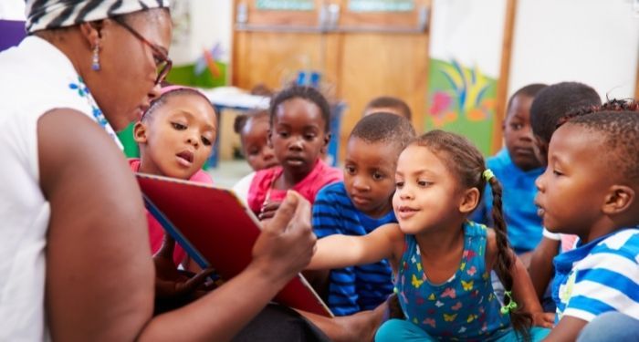 image of a Black teacher reading to Black students