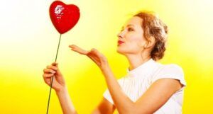 image of a white woman holding a red balloon.
