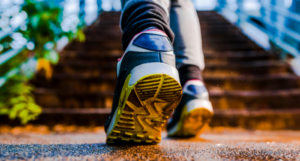 a photograph showing a close up on someone's sneakers as they prepare to run up stairs