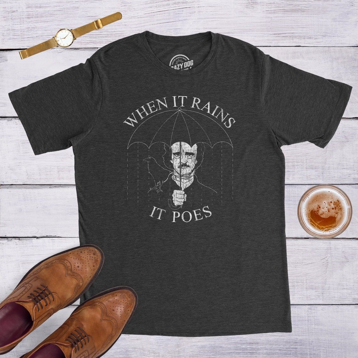 photo of Edgar Allan Poe shirt where he is holding an umbrella that says "when it rains, it Poes"