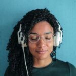 Image of a Black woman listening through headphones