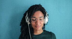 Image of a Black woman listening through headphones