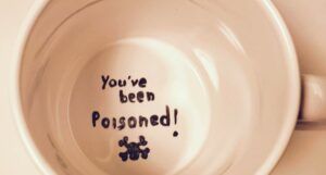 the inside of a mug with the words "you've been poisoned" and a small black skull & crossbones