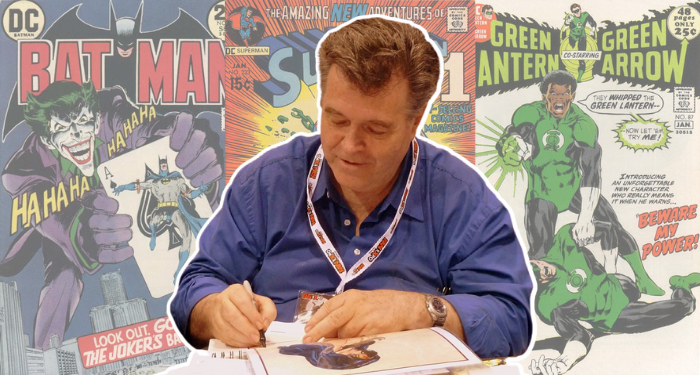 a photo of Neal Adams signing prints at a convention with his comic covers in the background