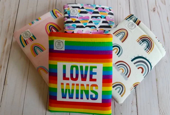 Four fabric book sleeves, all with different rainbow designs. The top one says "Love wins"