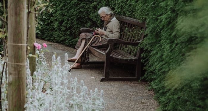 light-skinned elderly lady reading bench