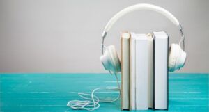 Image of white headphones on top of a stack of books.