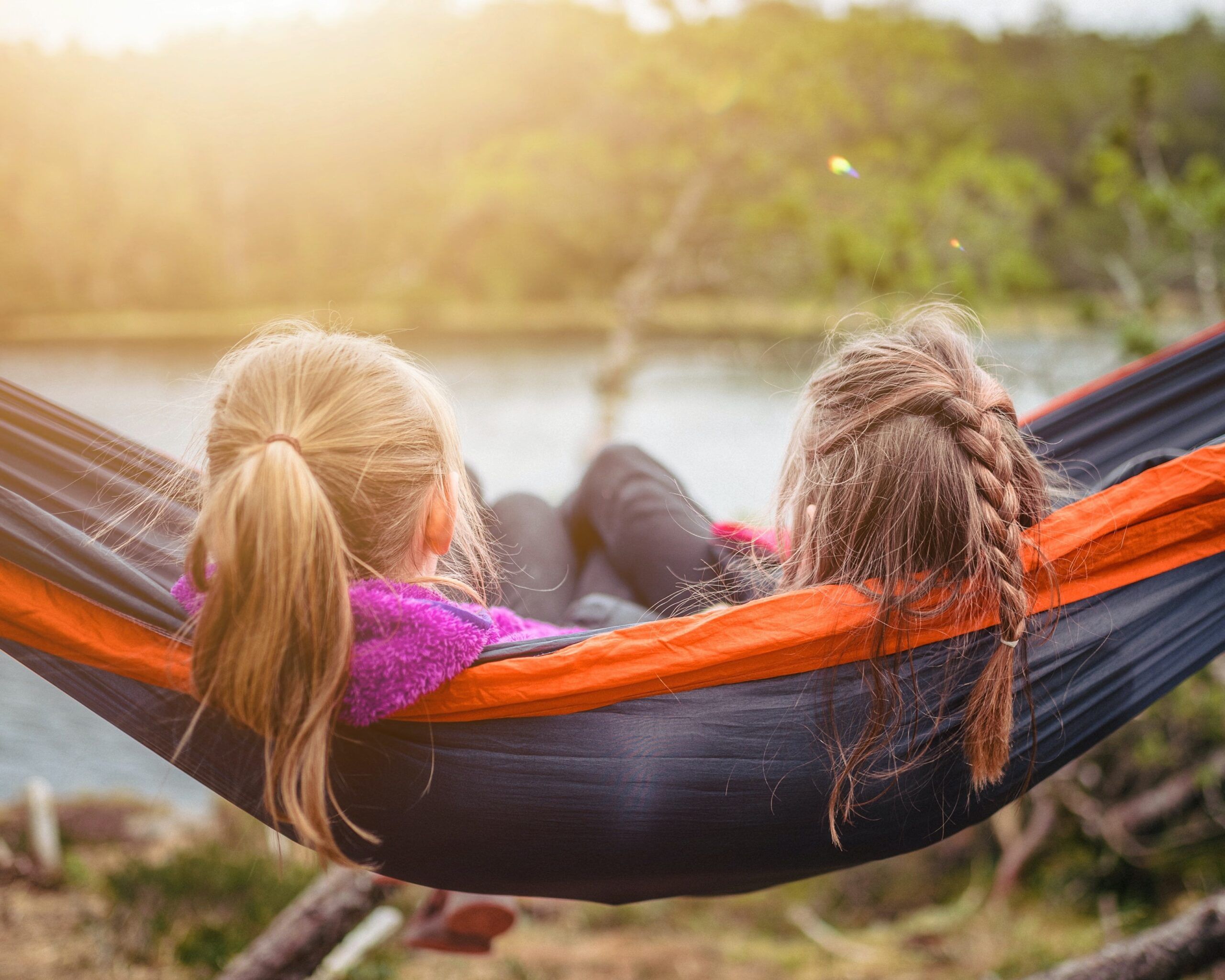 Image of two people in a hammock. Both have blonde hair