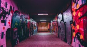 graffiti on two sides of a dark walkway with mysterious vibes