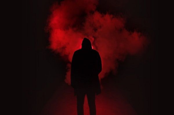  a silhouette of a figure against red smoke