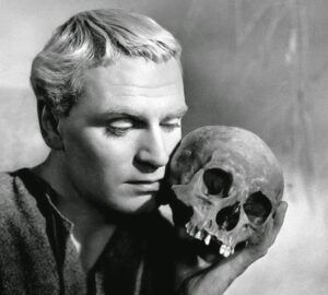 Black and white photo of Laurence Olivier as Hamlet, holding Yorick's skull