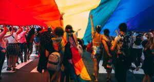 a photo of a Pride Parade with a giant rainbow flag