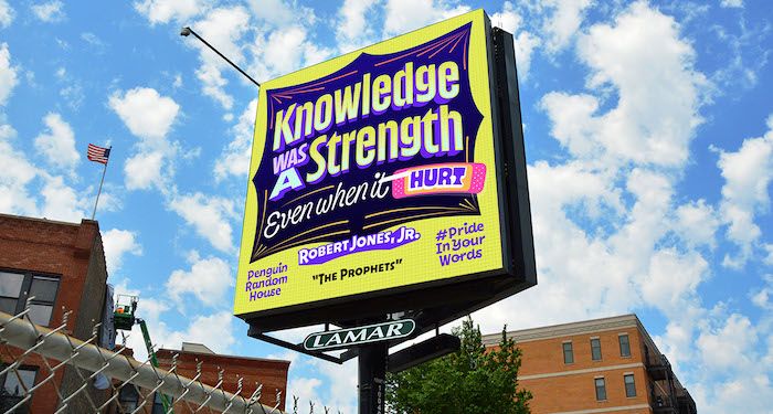 a photo of a billboard with artistic lettering reading "Knowledge was a strength even when it hurt." - Robert Jones, Jr., The Prophets