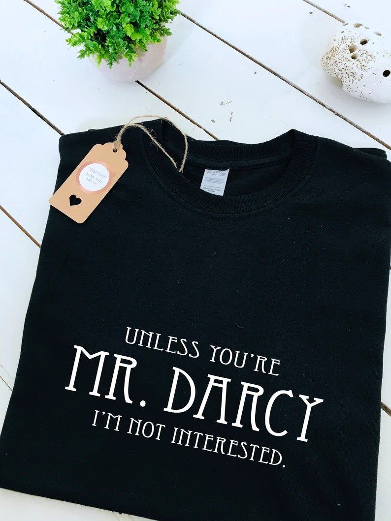 Photo of a black t-shirt with the quote 'Unless you're Mr. Darcy I'm not interested' printed in white letters. 