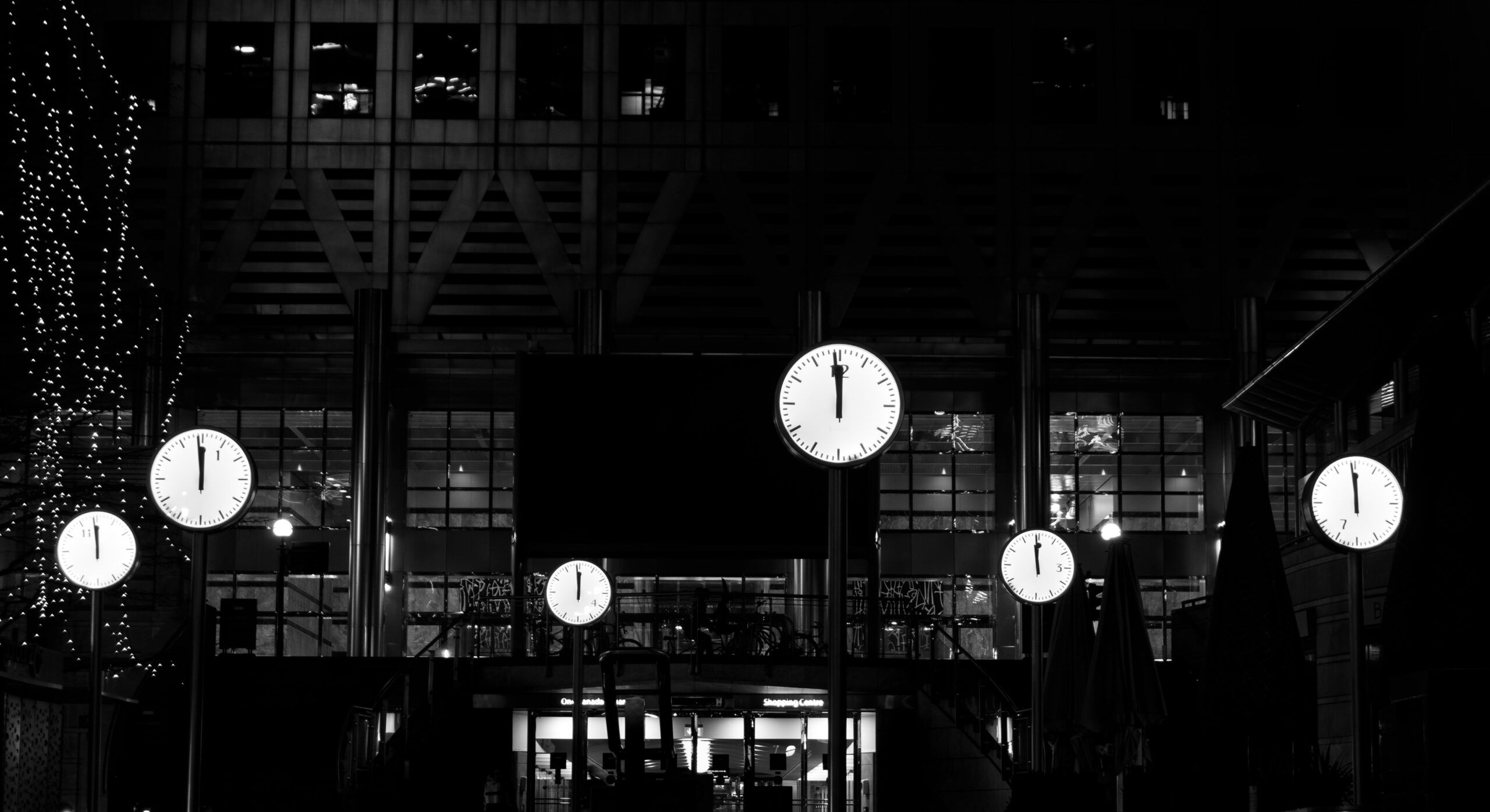 a black and white photo of several clocks at midnight