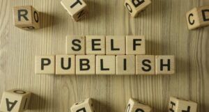 tan letter tiles forming the words "self publish"