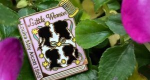 a photo of a Little Women book cover enamel pin