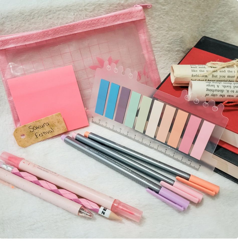 Image of a pastel pink annotation kit, including pens, a highlighter, sticky notes, and a pink pouch. 