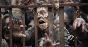 a still from The Walking Dead showing a horde of zombie reaching through bars