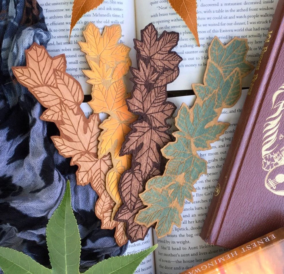 Image of several wooden bookmarks in the shape of leaves. 