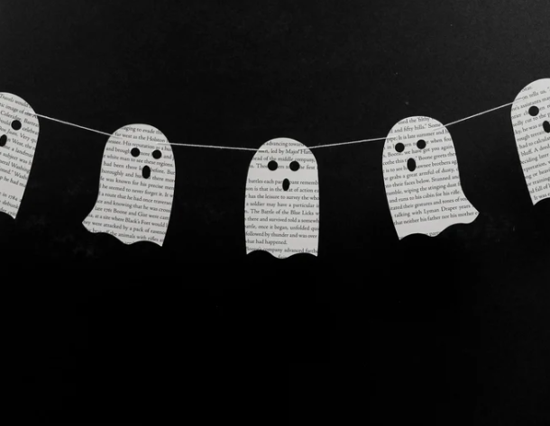 A garland of ghosts made from cutout book pages