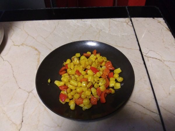 Author photo of a plate of corn kernels and red pepper mixed together