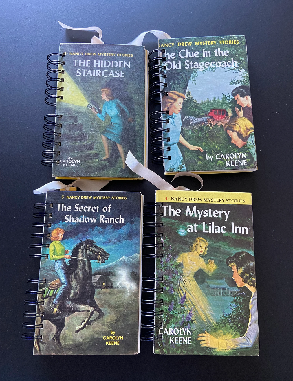 Four Nancy Drew books that have been repurposed into notebooks
