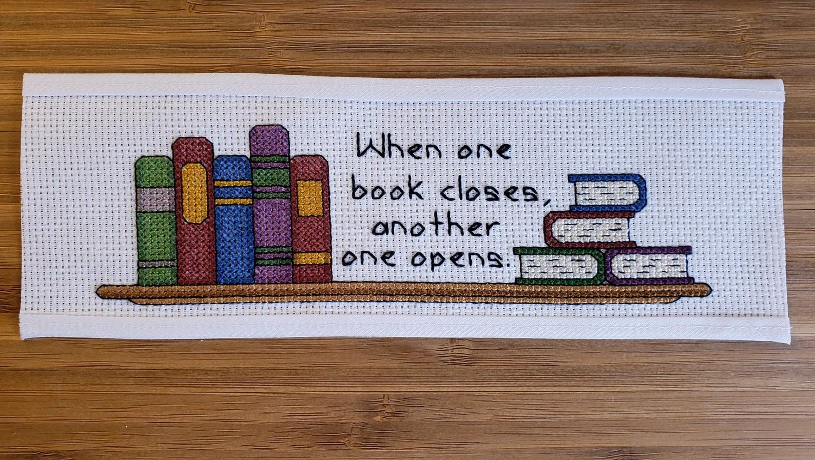 a photo of a Book Cross Stitch Bookmark Kit that says, "When on book closes, another one opens."