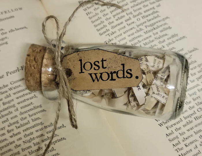 small glass bottle labeled "lost words"