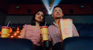 lightly tanned-skinned man and woman sitting in a theater