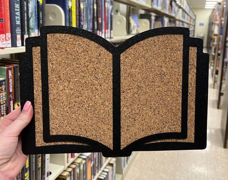 Image of a cork board in the shape of a book. 