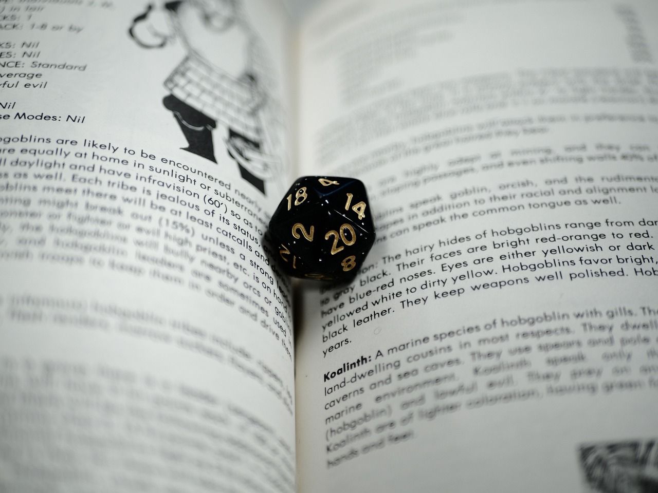 A black 20-sided die with gold lettering rests on the open pages of a Dungeons and Dragons Monster Manual book. 