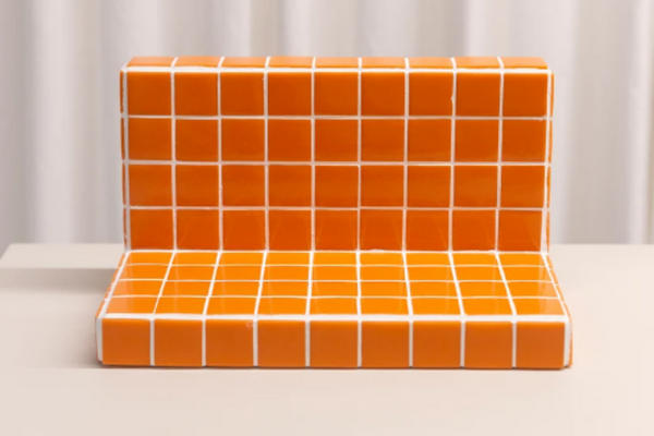 Small floating wall shelf in orange tiles.