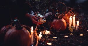 Halloween decorations with lights and a hand holding an animal skull