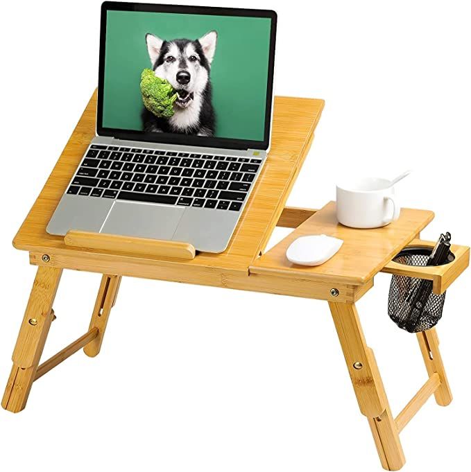 A wooden laptop stand designed to sit across a lap. It has various levels and a holder for a cup or pens. 