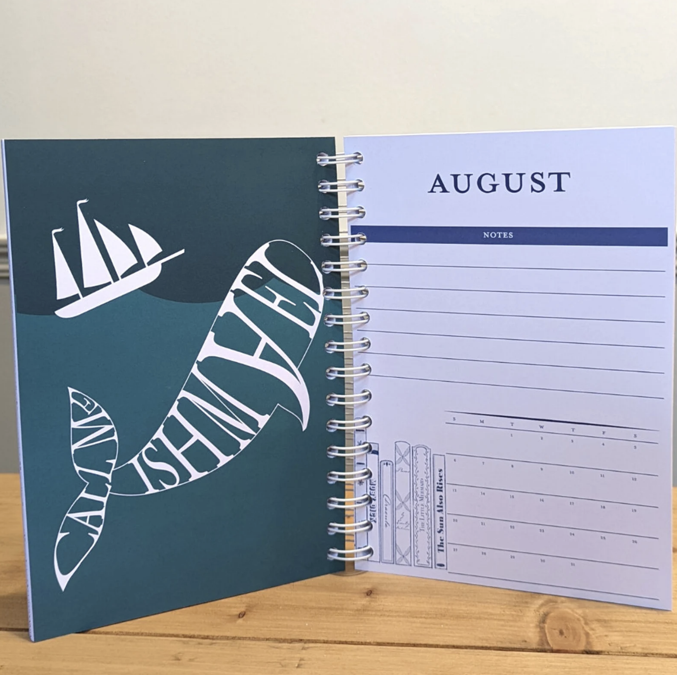 open planner with an image of a whale made up of the letters call me ishmael next to the first page of the month of august section of the planner