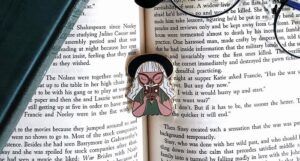 an enamel pin of a woman inhaling a book